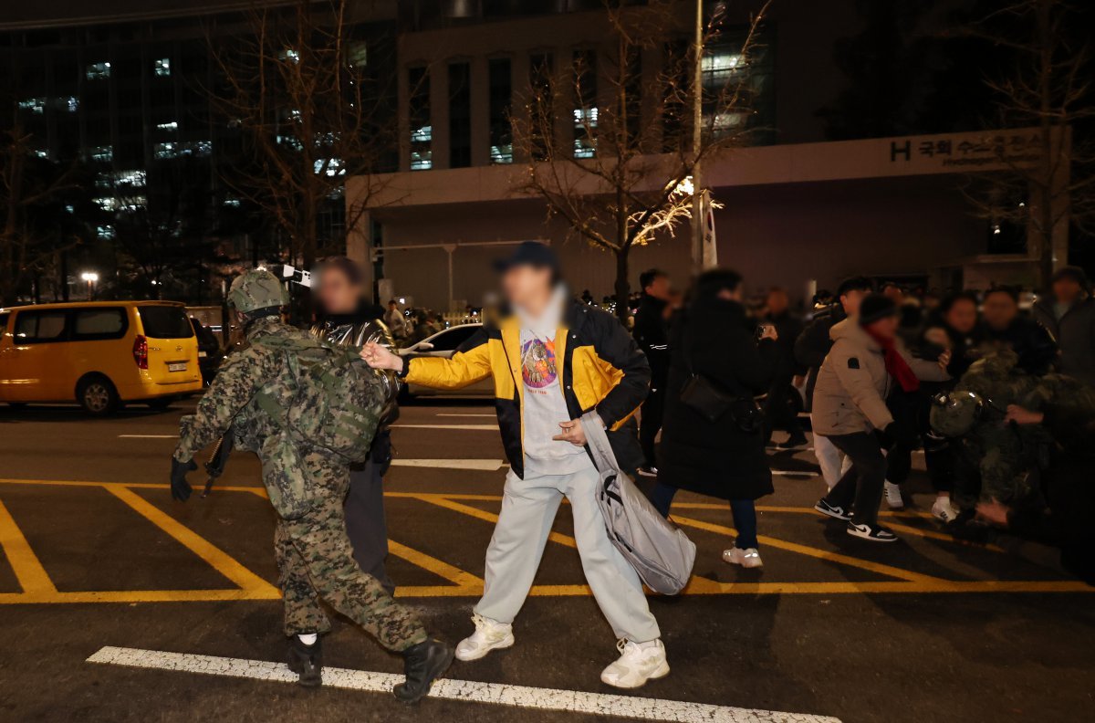 윤석열 대통령이 비상계엄령을 전격 선포한 가운데 4일 새벽 서울 여의도 국회 앞에서 시민들이 경내로 진입하려는 계엄군을 붙잡아 막아서고 있다. 2024.12.4/뉴스1