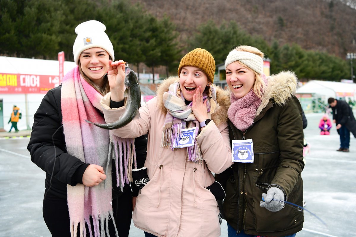 산천어를 잡고 즐거워하는 외국인 관광객들.