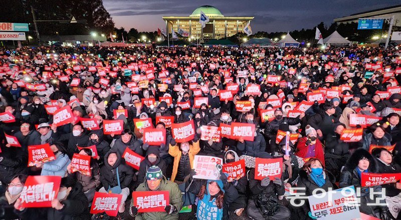 여의도선 “윤석열 탄핵” 7일 오후 서울 영등포구 여의도 국회의사당 앞에서 열린 범국민촛불대행진에서 시민들이 윤석열 대통령 탄핵소추안 통과를 촉구하는 집회를 열고 있다. 시민들이 ‘윤석열을 거부한다’고 적힌 피켓을 들고 구호를 외치고 있다. 전영한 기자 scoopjyh@donga.com