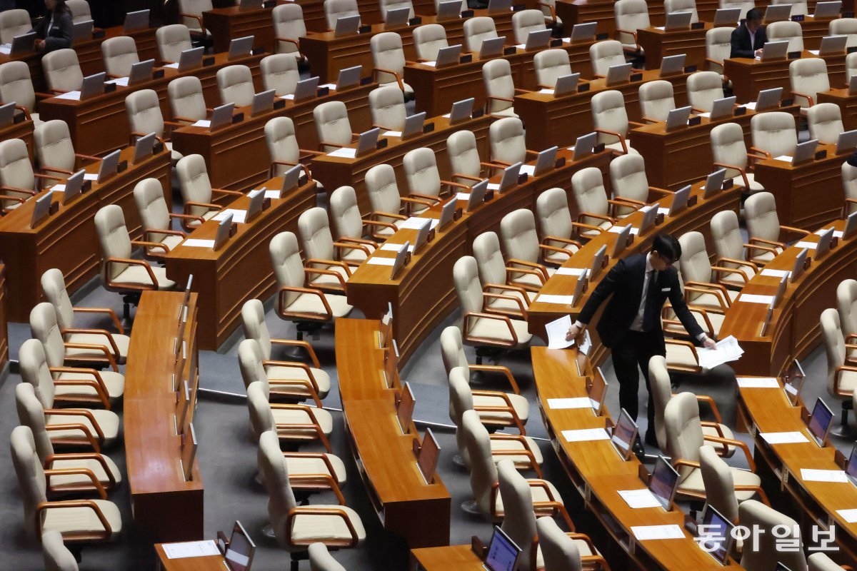 14일 국회 본회의장에서 한 국회 직원이 본회의가 산회된 후 뒷정리를 하고 있다. 박형기 기자 oneshot@donga.com