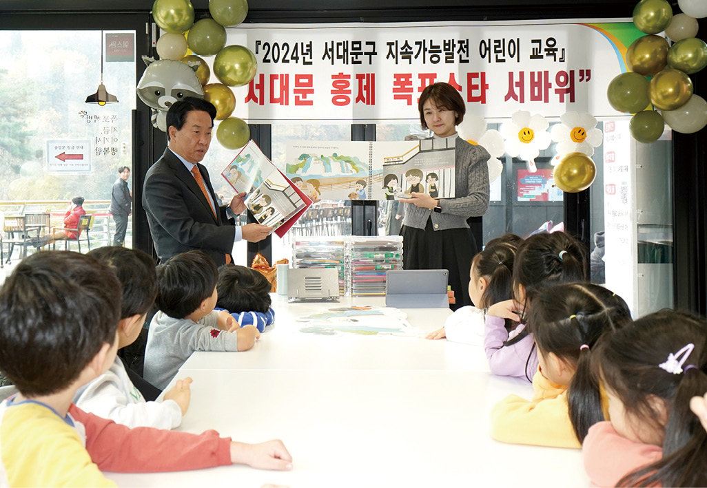 이성헌 서대문구청장(왼쪽)이 ‘서대문 홍제폭포스타 서바위’ 그림책을 어린이들에게 읽어주고 있다. 서대문구 제공