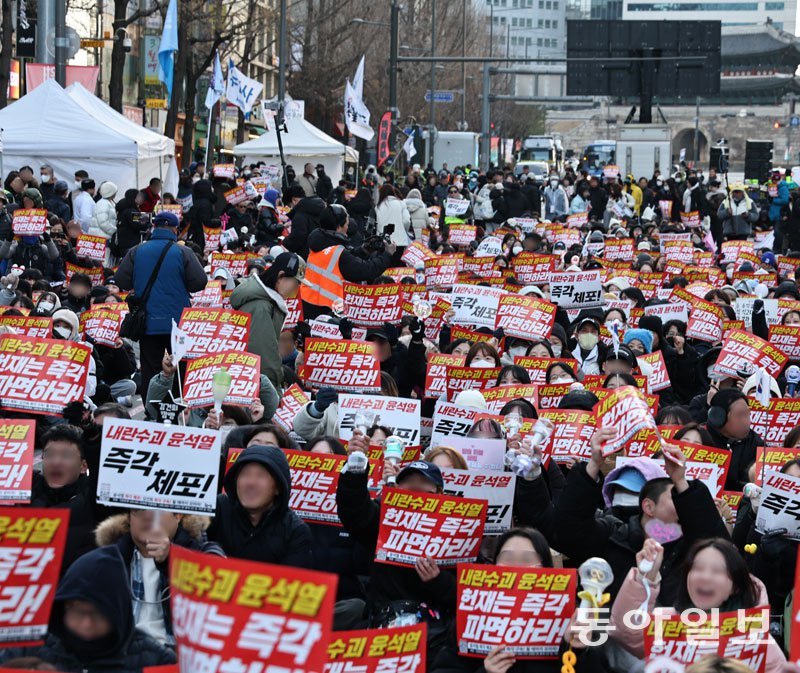 “즉각 체포” 윤석열 대통령 탄핵소추안이 국회를 통과한 다음 날(15일) 서울 중구 세종대로에서 윤 대통령의 파면을 요구하는 집회가 열렸다. 집회 참가자들이 손에 ‘내란 수괴 윤석열 즉각 체포’ 등이 적힌 팻말을 들고 있다. 양회성 기자 yohan@donga.com