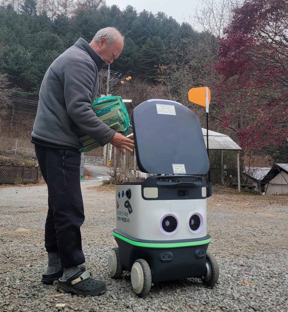 경기 가평군 ‘산으로간니모’ 캠핑장에서 캠핑객이 주문한 장작 등을 배달 로봇에 싣는 모습. 한국관광공사 제공