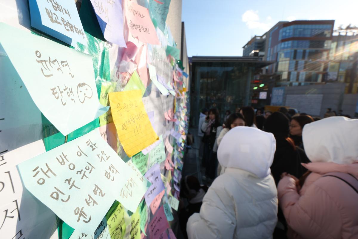 이화여대 재학생들이 6일 오후 서울 서대문구 이화여대 앞에서 윤석열 대통령의 퇴진을 촉구하는 시국 선언을 한 후 대자보에 메시지를 붙이고 있다. 2024.12.6/뉴스1