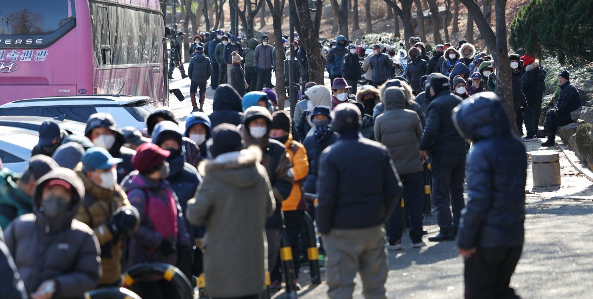 올겨울 가장 추운 날씨를 보인 21일 대구 달서구 두류공원에 마련된 ‘사랑해 밥차’ 무료 급식소를 찾은 어르신들이 점심 배식을 받기 위해 줄을 서고 있다. 2023.12.21. 대구=뉴시스