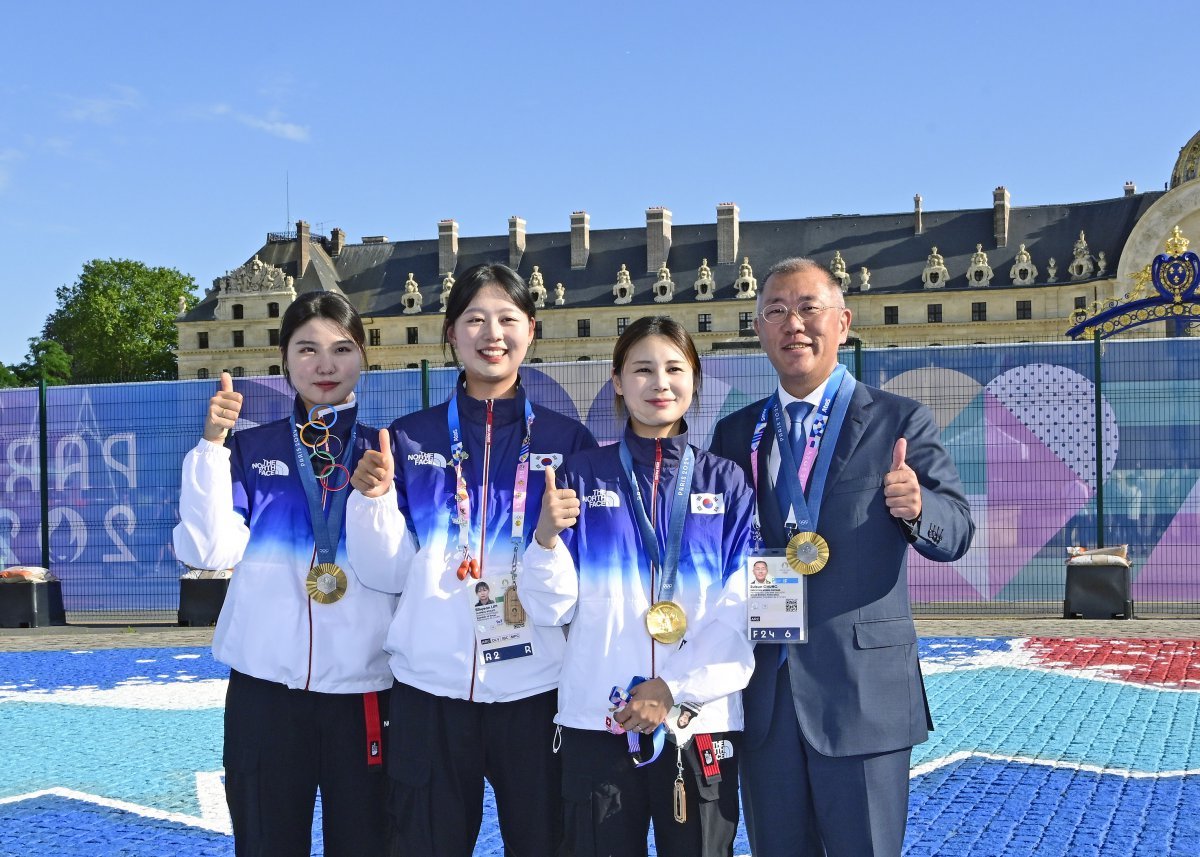 정의선 현대자동차그룹 회장(오른쪽)이 2024 파리올림픽에서 여자 단체전 금메달을 따낸 대표팀과 함께 프랑스 파리 앵발리드에서 기념 촬영을 하고 있다. 현대자동차그룹 제공