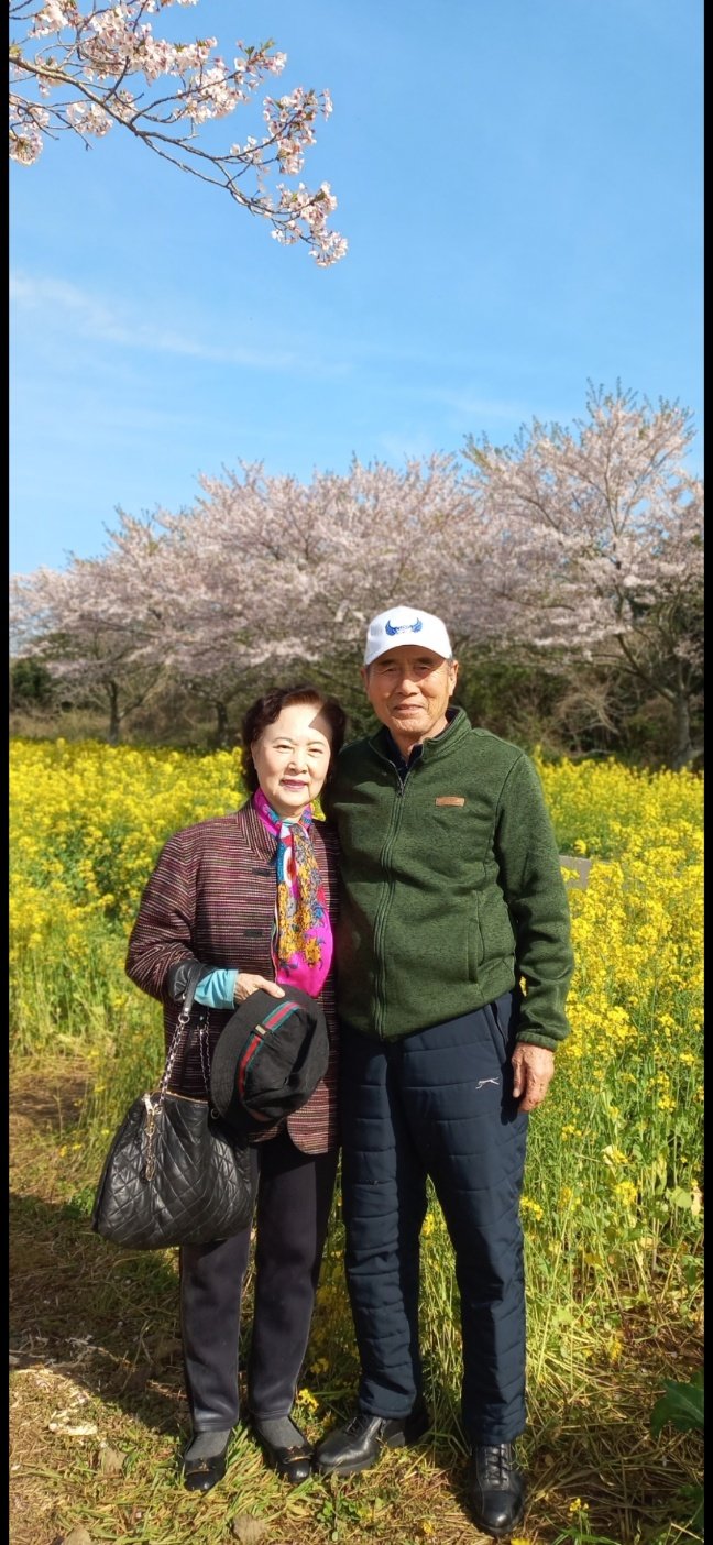 유백만 감독과 아내 이정자 씨자 제주 유채꽃을 배경으로 사진을 찍었다. 유백만 감독 제공