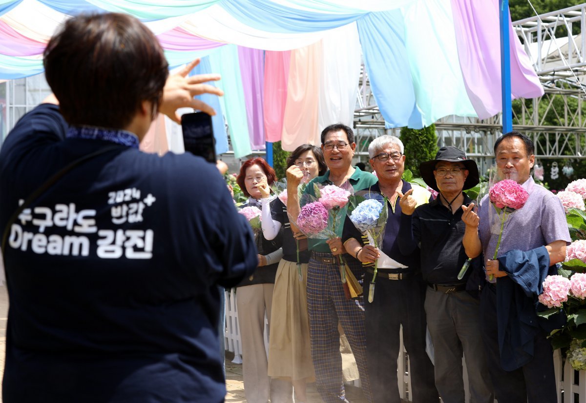 6월 강진 수국길 축제를 찾은 관광객들이 수국을 들고 사진을 찍고 있다. 강진군은 누구나 반값 여행 덕분에 올해 관광객이 크게 늘었다. 강진군 제공