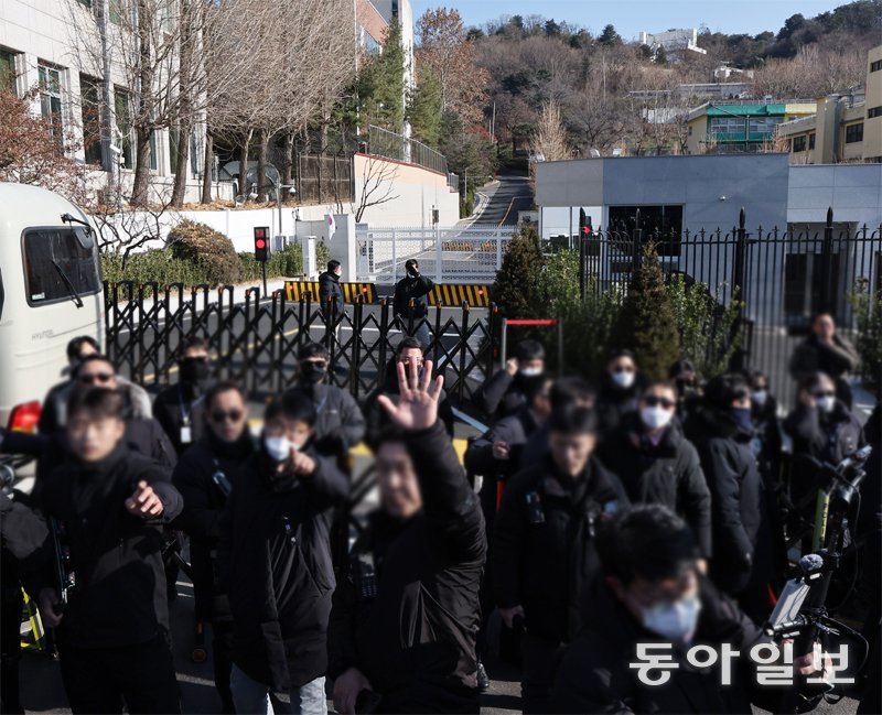 긴장감 도는 대통령 관저 앞 2일 오후 서울 용산구 한남동 대통령 관저 입구에서 마스크와 선글라스를 착용한 경찰이 경계 근무를 서는 가운데 한 경찰이 손을 들어 취재진의 사진 촬영을 막고 있다. 이날 관저 앞에서는 윤석열 대통령의 지지자들과 반대 진영의 집회가 함께 열려 양측이 일부 충돌하기도 했다. 양회성 기자 yohan@donga.com