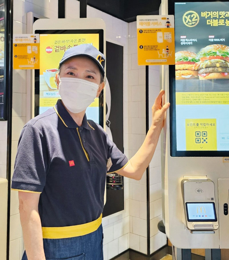 서울 은평구 한 맥도날드 매장에서 윤미희 씨가 주문 키오스크 옆에 서 있다. 윤 씨는 2023년 10월 서울시50플러스 서부캠퍼스의 취업 지원을 받아 맥도날드 크루로 활동하고 있다. 서울시50플러스재단 제공