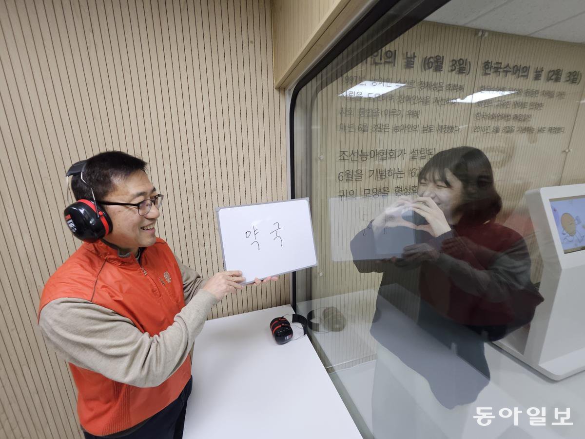 7일 오후 서울 서대문구 시립 서대문농아인복지관 별관에 자리한 ‘청각장애체험관’을 찾은 방문객(왼쪽)이 유리 너머 사람의 입 모양을 보고 유추한 단어를 화이트보드에 적어 들어 보이고 있다. 다른 사람의 입 모양을 읽는 ‘독화’ 체험이다. 서울시는 청각장애에 대한 이해와 인식을 개선하기 위해 지난해 12월 19일 전국 최초로 청각장애체험관을 열었다. 김동주 기자 zoo@donga.com