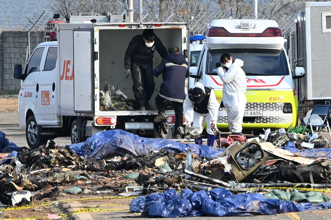 국토교통부 항공철도사고조사위원회 소속 감식반이 8일 오전 전남 무안군 무안국제공항 내 제주항공 여객기 참사 현장에서 사고 여객기 잔해물을 수거하고 있다. 뉴시스