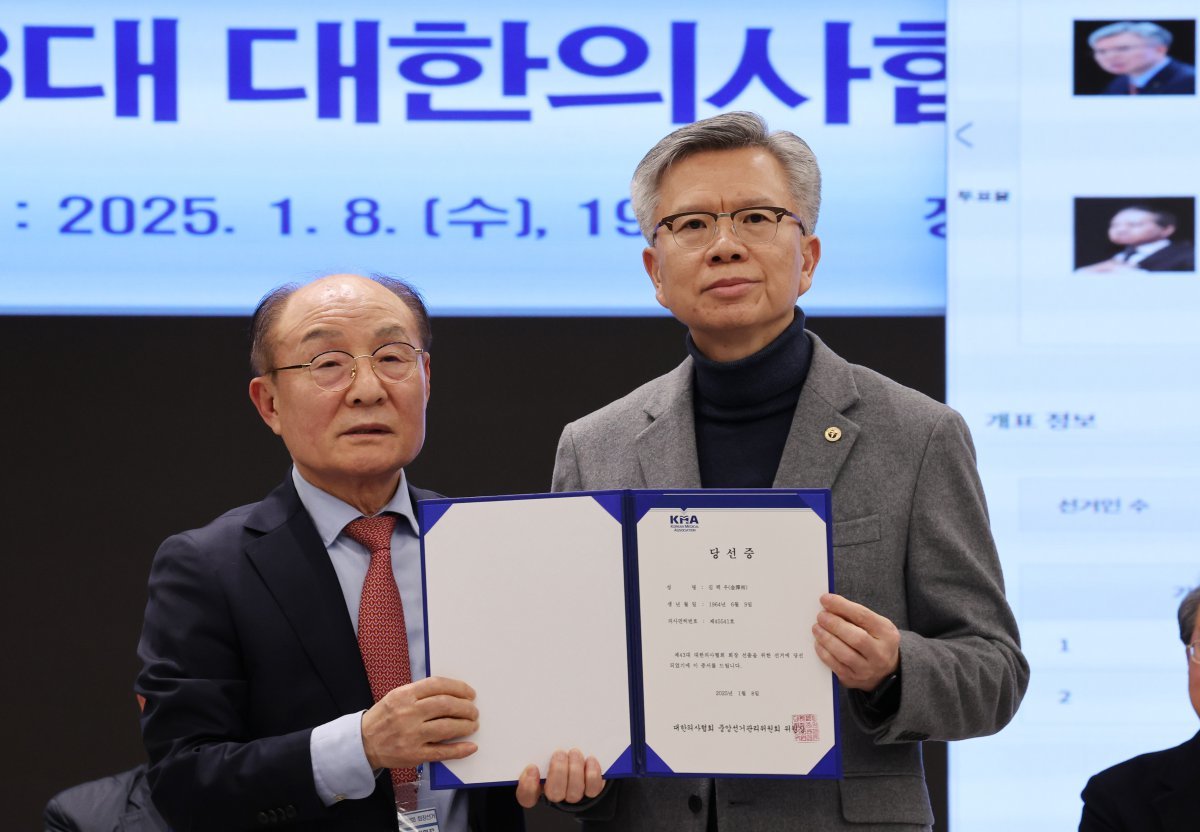 제43대 대한의사협회 회장에 당선된 김택우 후보가 8일 서울 용산구 대한의사협회 회관 대강당에서 고광송 의협 중앙선거관리위원장에게 당선증을 전달받고 있다. 2025.1.8. 뉴스1