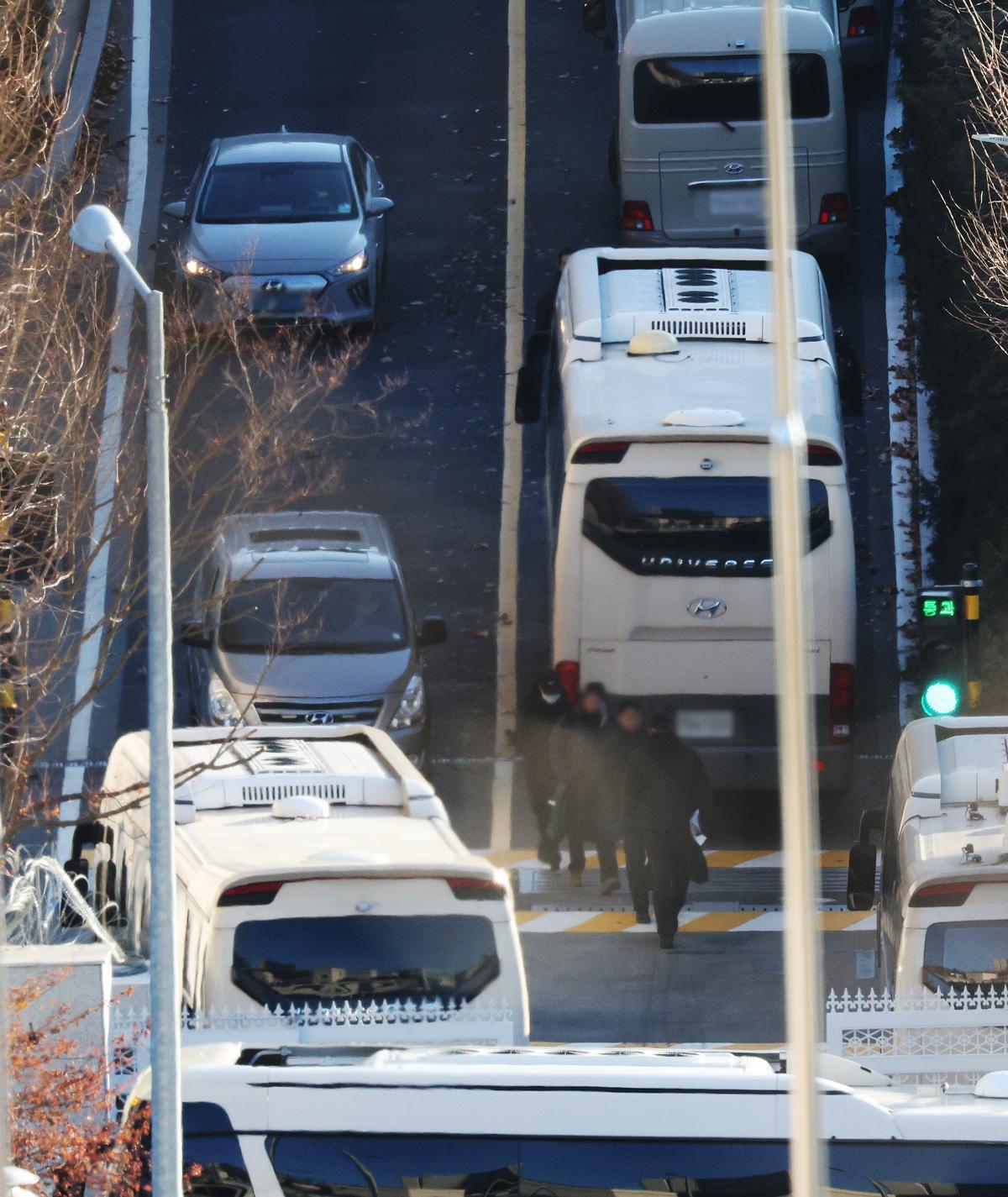 내란수괴 혐의를 받는 윤석열 대통령에 대한 체포영장이 재발부된 가운데 9일 오전 서울 용산구 한남동 대통령 관저에서 차벽을 세우기 위해 동원된 버스 차량 옆으로 경호처 등 관계자들이 이동하고 있다. 2025.1.9/뉴스1