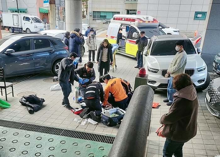 119 구급대원들이 홍은2동주민센터 후문 계단 아래에 쓰러진 70대 남성 A씨에게 응급조치를 시행하고 있다. 사진제공=서대문구