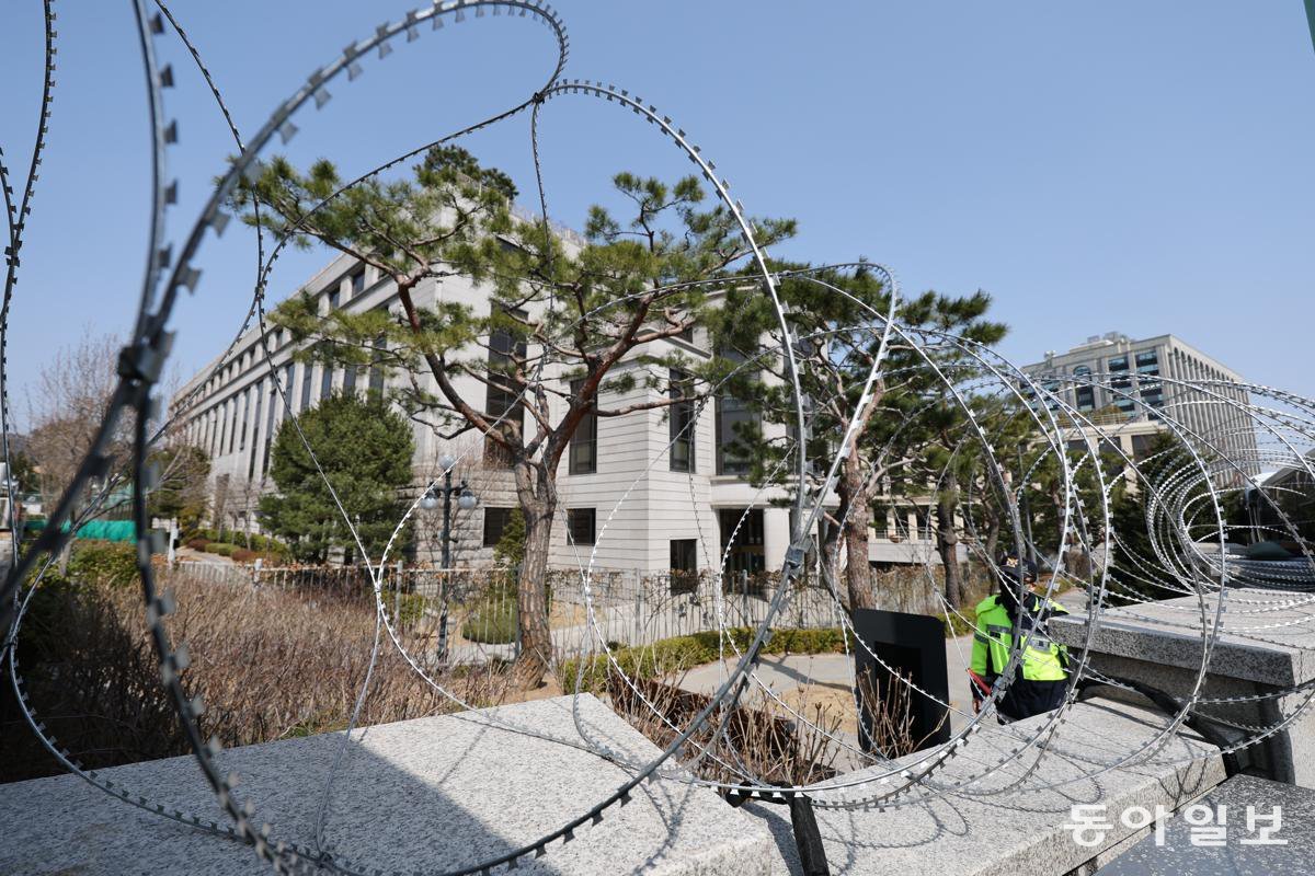 철조망 설치된 헌재… 경찰 “尹 탄핵심판 선고 당일 갑호비상” 윤석열 대통령 탄핵심판 선고 기일이 다가오는 가운데 서울 종로구 헌법재판소 인근 경비 태세가 한층 강화됐다. 14일 헌재 담장 일부 구간에는 원형 철조망이 설치됐다. 올해 1월 서울 용산구 한남동 대통령 관저 인근에도 윤석열 대통령 체포를 저지하기 위해 경호처가 이와 유사한 원형 철조망을 설치했다. 경찰은 헌재 선고 당일 폭력 시위나 테러 등을 우려해 갑호비상을 발령할 계획이다. 전영한 기자 scoopjyh@donga.com