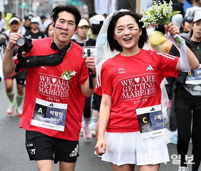 유모차 밀고, 웨딩 부케 들고, 장애인 손잡고, 대기업 회장도… 서울 달렸다 예비부부 박형민, 구혜인 씨는 ‘우리 결혼해요’가 적힌 티셔츠를 입고 10km 코스를 완주한 뒤 부케를 들고 포즈를 취했다. 양회성 기자 yohan@donga.com