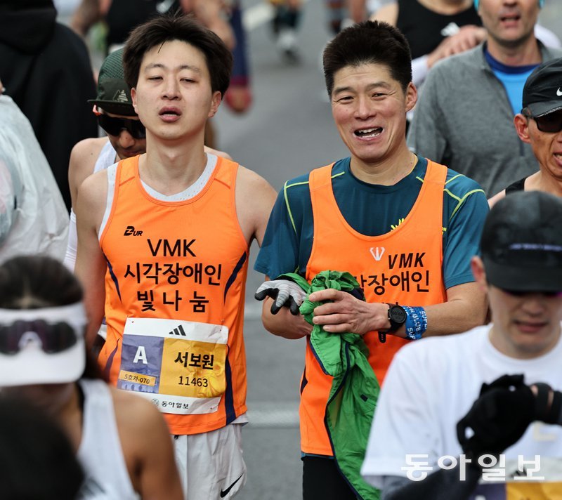 유모차 밀고, 웨딩 부케 들고, 장애인 손잡고, 대기업 회장도… 서울 달렸다 시각장애인 참가자 서보원 씨(왼쪽)가 가이드러너 김용정 씨의 손을 잡고 달리고 있다. 양회성 기자 yohan@donga.com