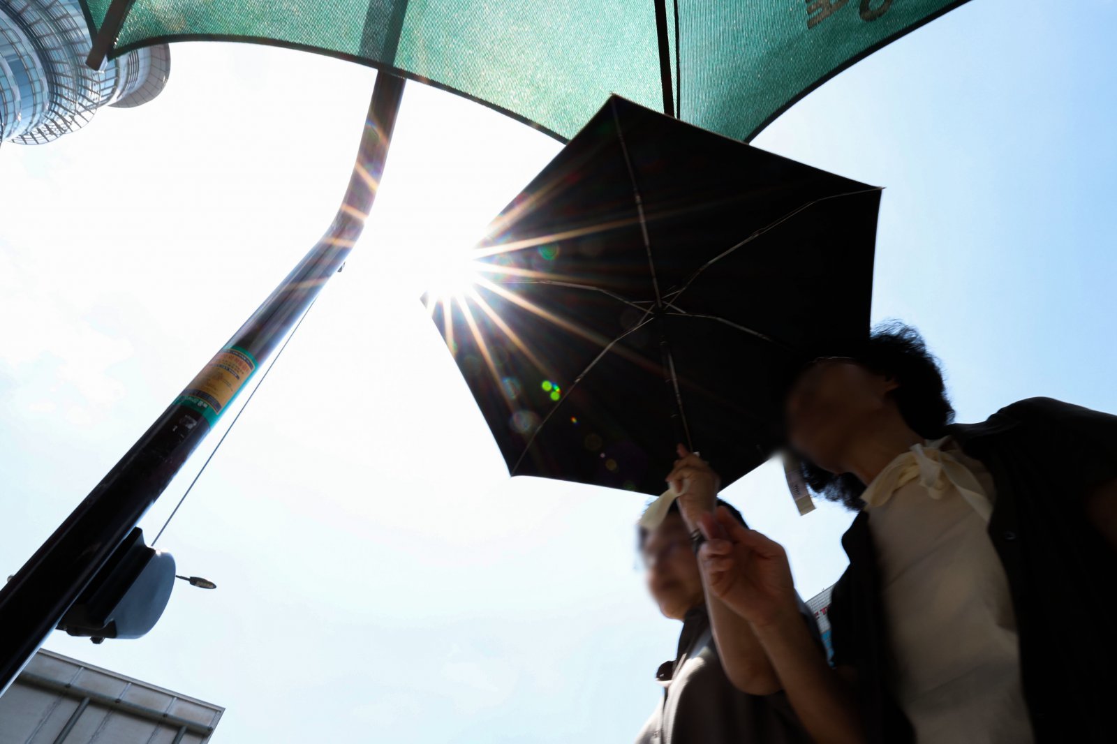 전국 대부분 지역에 폭염특보가 발효된 21일 서울 종로구 광화문광장 인근에서 시민들이 그늘막 아래서 햇빛을 피하며 신호를 기다리고 있다. 2025.08.21 뉴시스