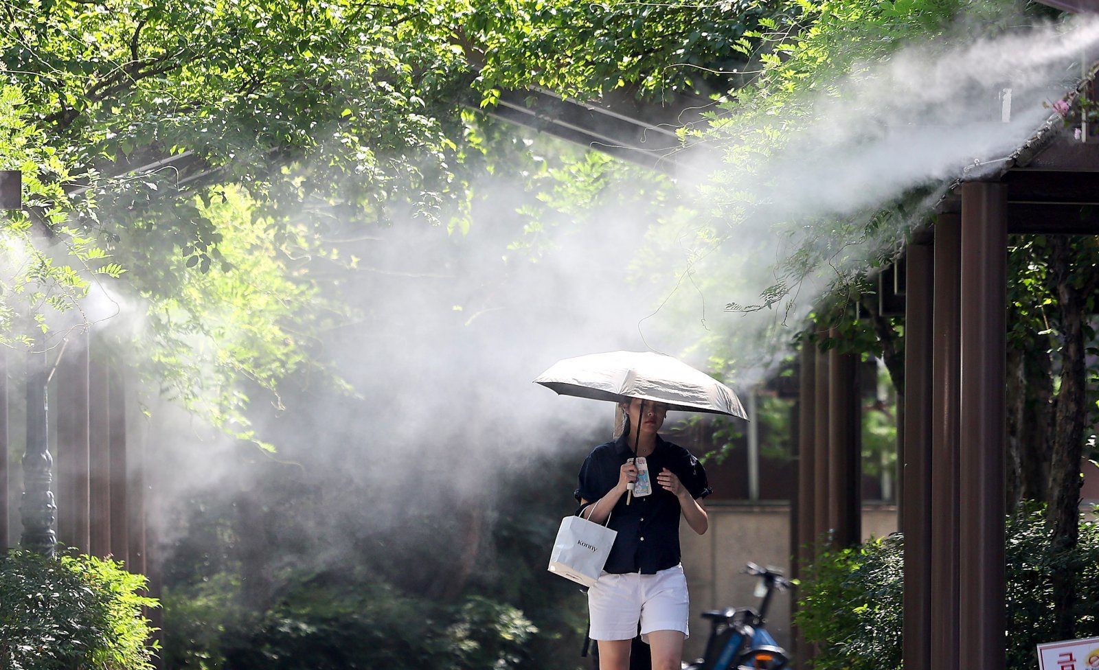 폭염이 연일 계속되고 있는 18일 대구 중구 국채보상운동기념공원에 설치된 쿨링포그 아래로 한 시민이 이동하고 있다. 2025.08.18. [대구=뉴시스]