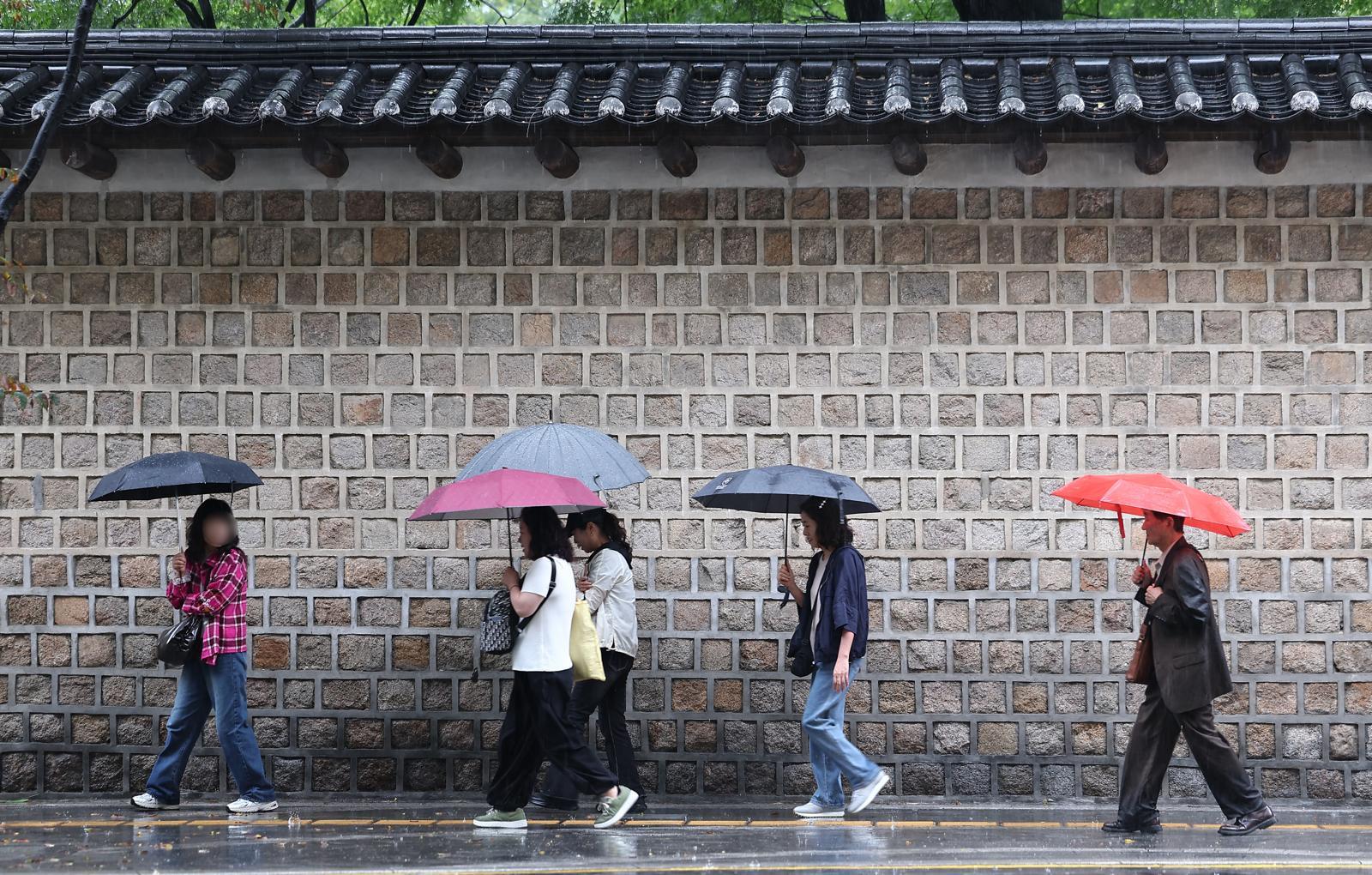 지난달 28일 서울 중구 덕수궁 돌담길에서 시민들이 우산을 쓴 채 발걸음을 옮기고 있다. 2025.9.28. 뉴스1