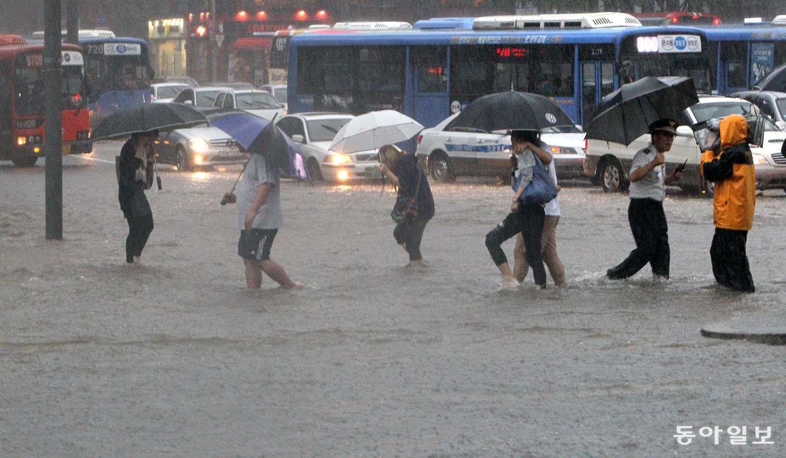 바지를 걷은 시민들이 물에 잠긴 광화문 사거리 건널목을 지나고 있다. 동아일보 DB