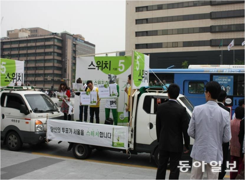 2010년 전국동시지방선거 때 책 ‘스위치’를 서울시장 후보로 내세워 홍보하는 모습을 시민들이 바라보고 있다. 웅진씽크빅 제공