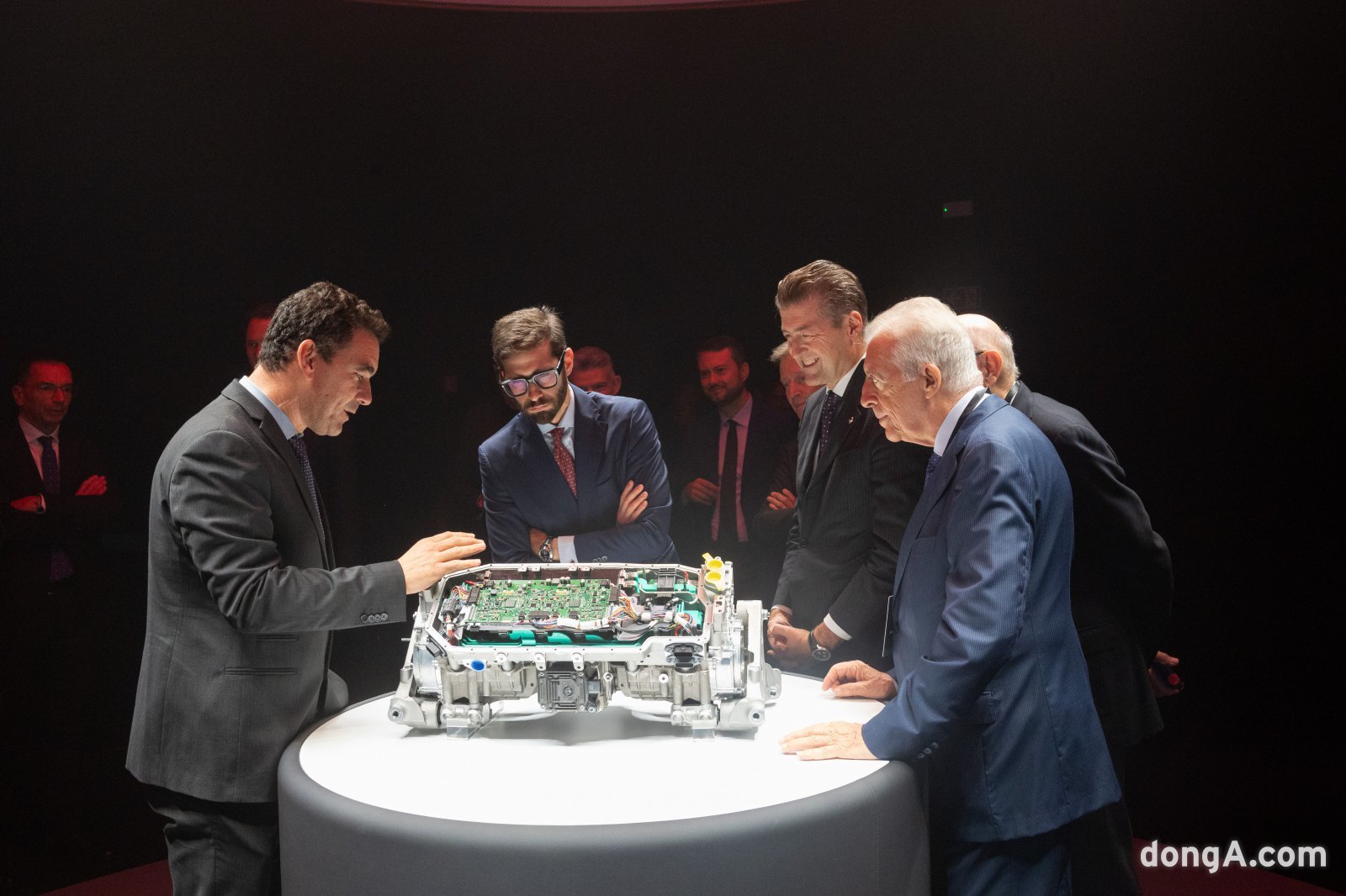 페라리 임원진들이 전기차 부품을 살펴보고 있다.