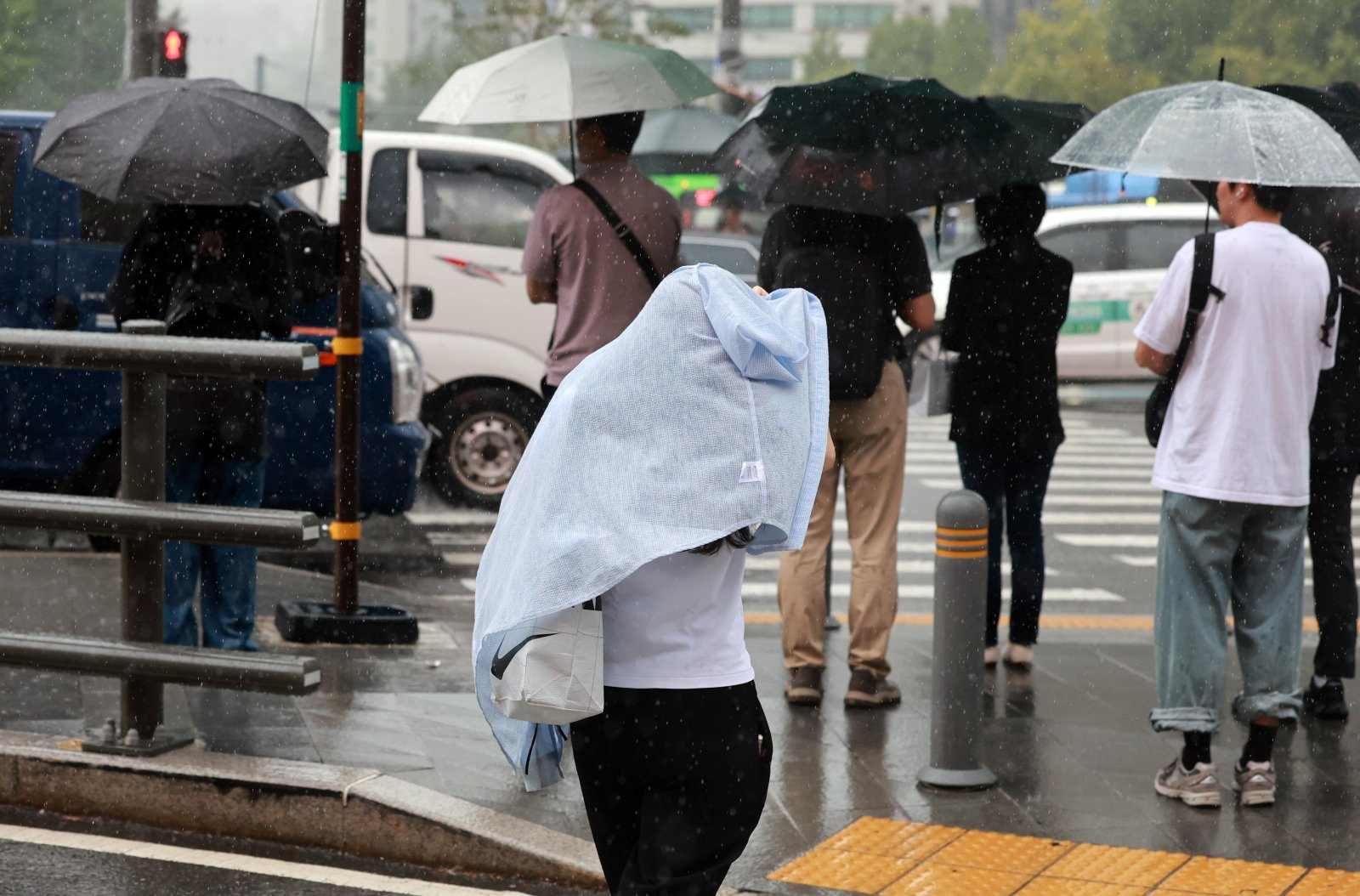 비가 내린 24일 오후 서울 종로구 광화문 네거리에서 한 시민이 옷으로 몸을 감싸며 걸어가고 있다. 2025.09.24 뉴시스