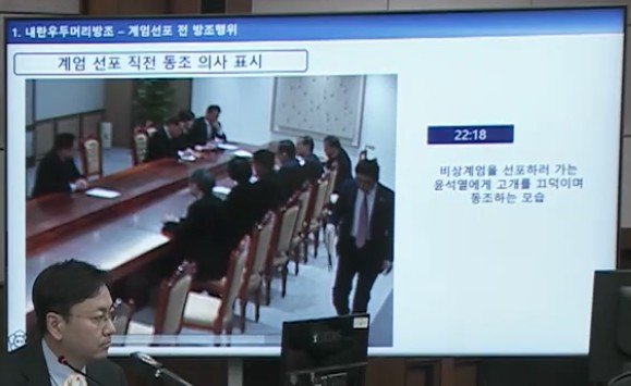 서울중앙지법 형사합의33부(부장판사 이진관) 심리로 열린 한덕수 전 국무총리 2차 공판에서 특검이 제시한 12·3 비상계엄 당일 대통령실 폐쇄회로(CC)TV 영상 화면에 윤석열 전 대통령이 대접견실에서 국무위원들을 상대로 무언가 말한 뒤 일어서는 모습이 재생되고 있다. 한 전 총리는 고개를 살짝 끄덕이고 있다. 법원 공판 중계 화면 캡처