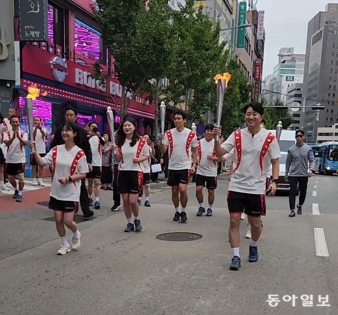13일 부산 연제구 연산교차로 인근 도로에서 제106회 전국체육대회 성화 봉송 주자들이 오른손에 은색 성화봉을 들고 천천히 달리고 있다. 김화영 기자 run@donga.com