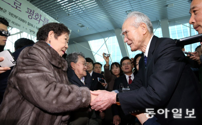 2014년 서울 영등포구 국회 의원회관에서 열린 위안부 피해자 할머지들의 작품 전시회에 참석한 무라야마 도미이치 전 일본 총리가 위안부 피해자 강일출 할머니의 손을 맞잡고 있다. 이훈구 기자 ufo@donga.com
