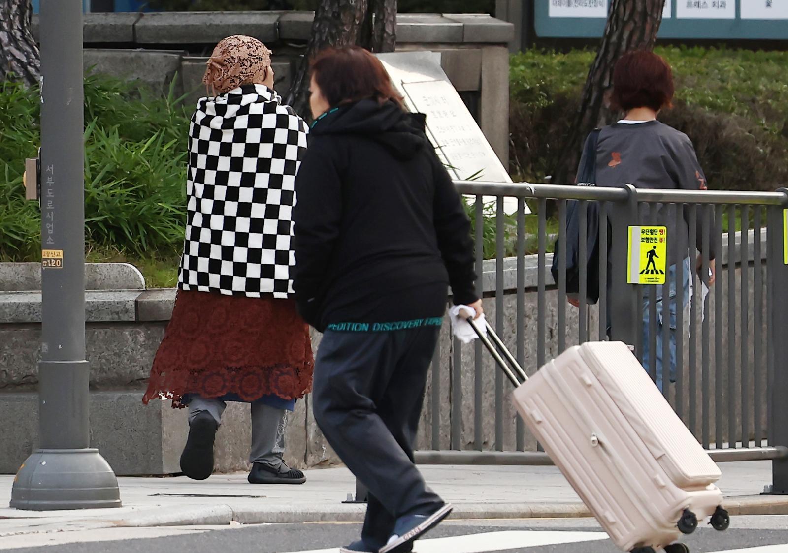서울을 비롯한 대부분 지역의 아침 최저 기온이 한 자릿수로 떨어지며 올가을 가장 추운 날씨를 보인 20일 오전 서울 시청역 인근에서 담요를 두른 시민이 이동하고 있다. 2025.10.20/뉴스1