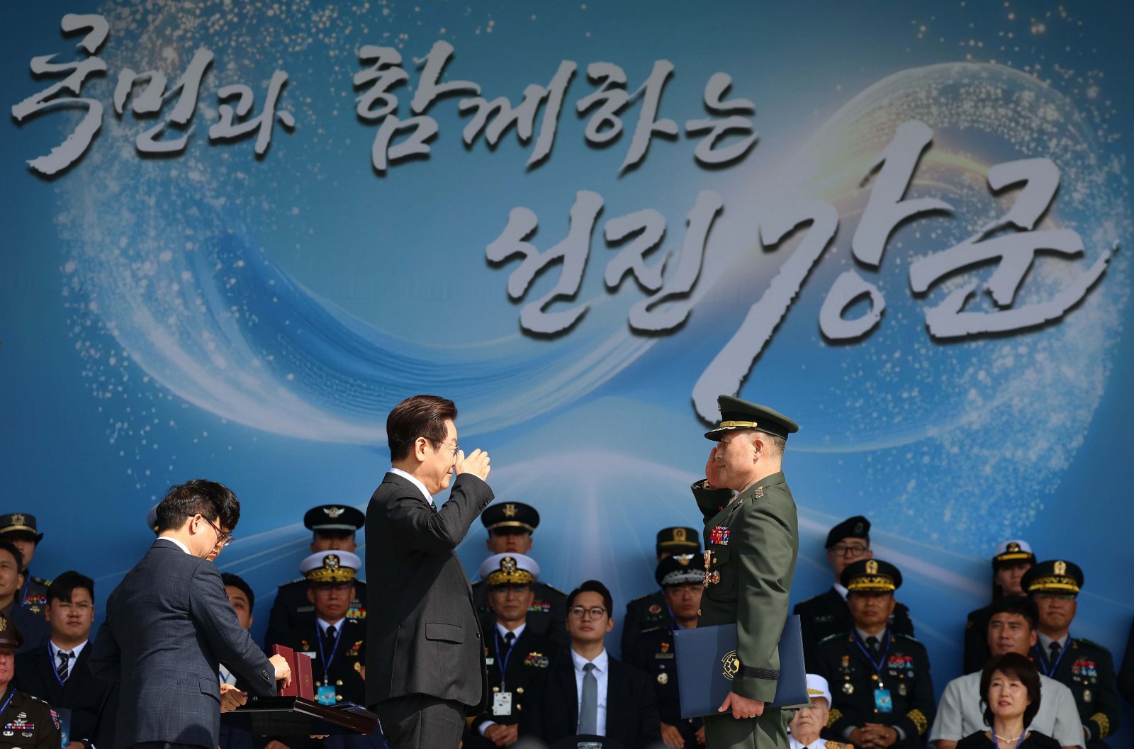 이재명 대통령이 1일 충남 계룡대에서 열린 건군 77주년 국군의 날 기념식에서 박정훈 해병대 수사단장(대령)에게 훈장을 수여한 뒤 경례하고 있다. 2025.10.01 뉴시스