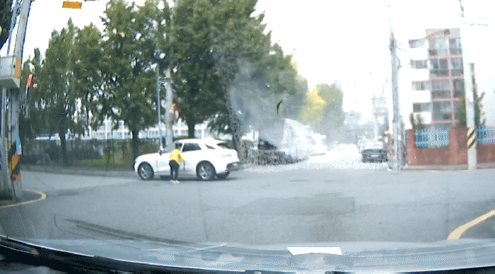 술을 뿌린 이후 북어를 들고 네 바퀴를 치는 여성. 그는 택시가 다가오자 북어를 택시 방향으로 던졌다. (출처=보배드림 캡처)