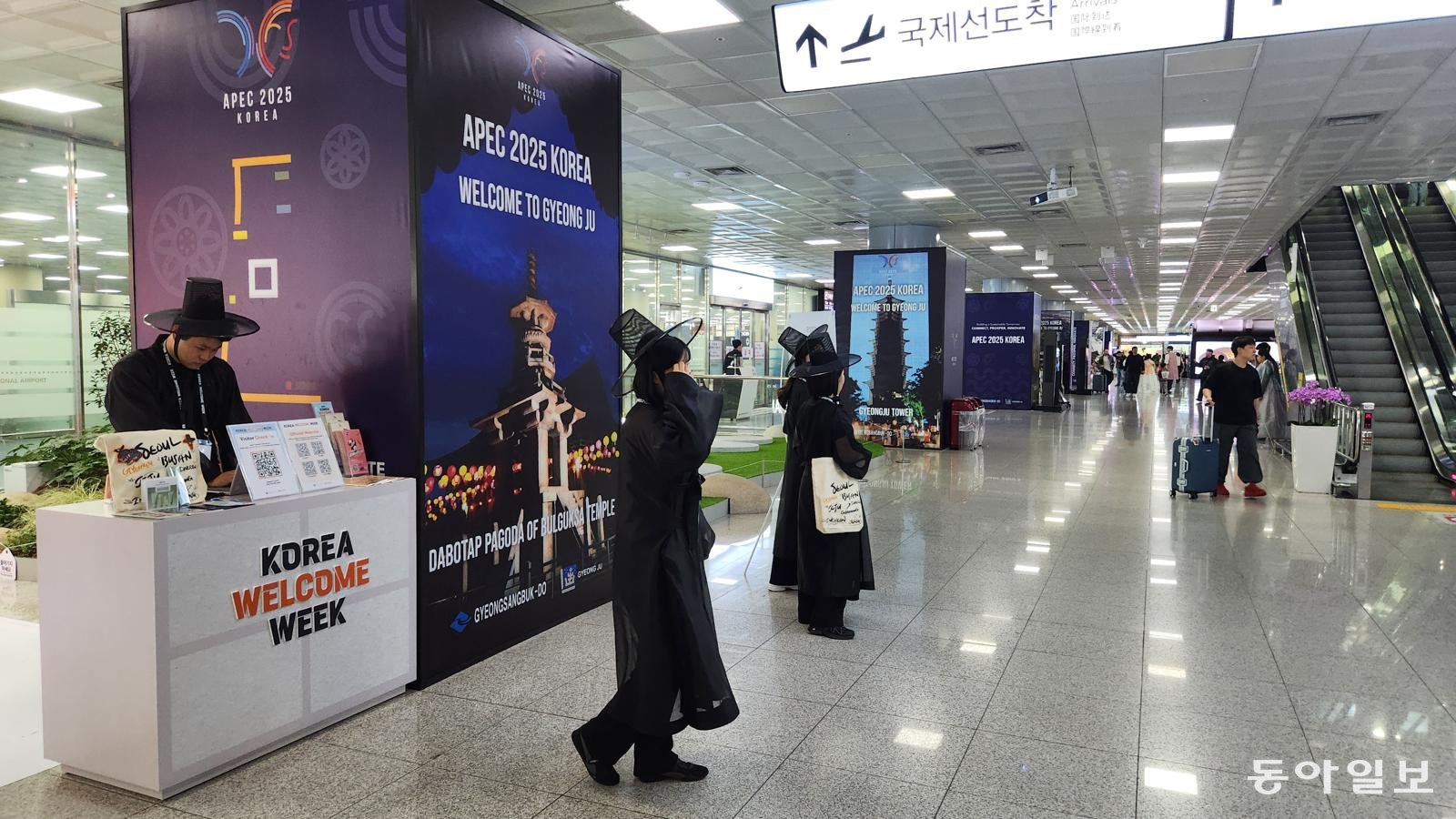 25일 오후 부산 강서구 김해국제공항 국제선 청사에서 넷플릭스 애니메이션 ‘케이팝 데몬 헌터스’의 저승사자 복장을 한 청년들이 외국인 방문객을 대상으로 홍보 활동을 하고 있다. 부산=김화영 기자 run@donga.com