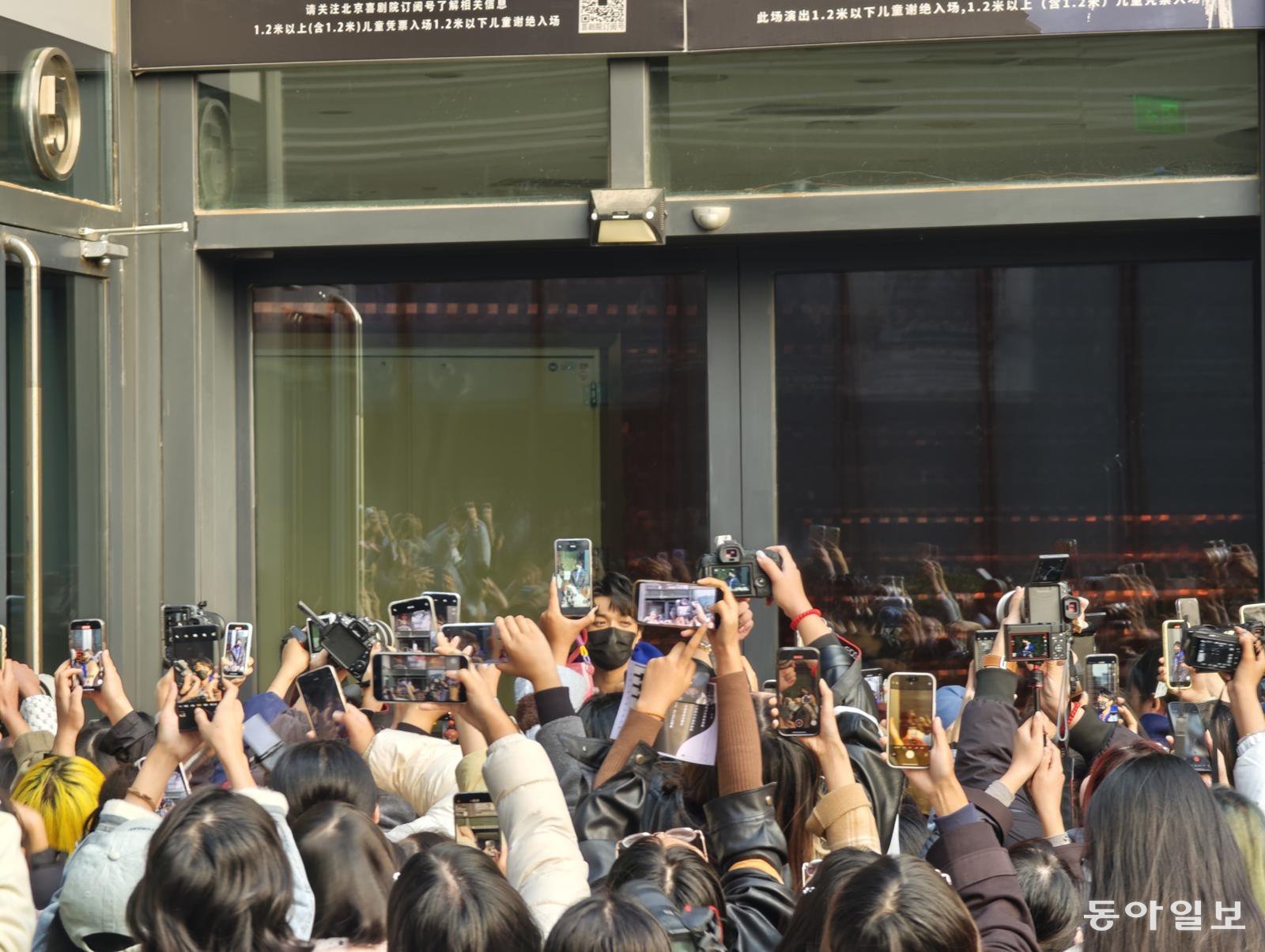 25일 한국 창작뮤지컬 ‘광염 소나타’의 라이선스 공연이 끝난 뒤 주연 배우인 왕민후이(王敏輝·가운데 검정 마스크를 쓴 남성)가 건물 밖으로 나와 팬들에게 인사를 건네고 있다. 베이징=김철중 특파원 tnf@donga.com
