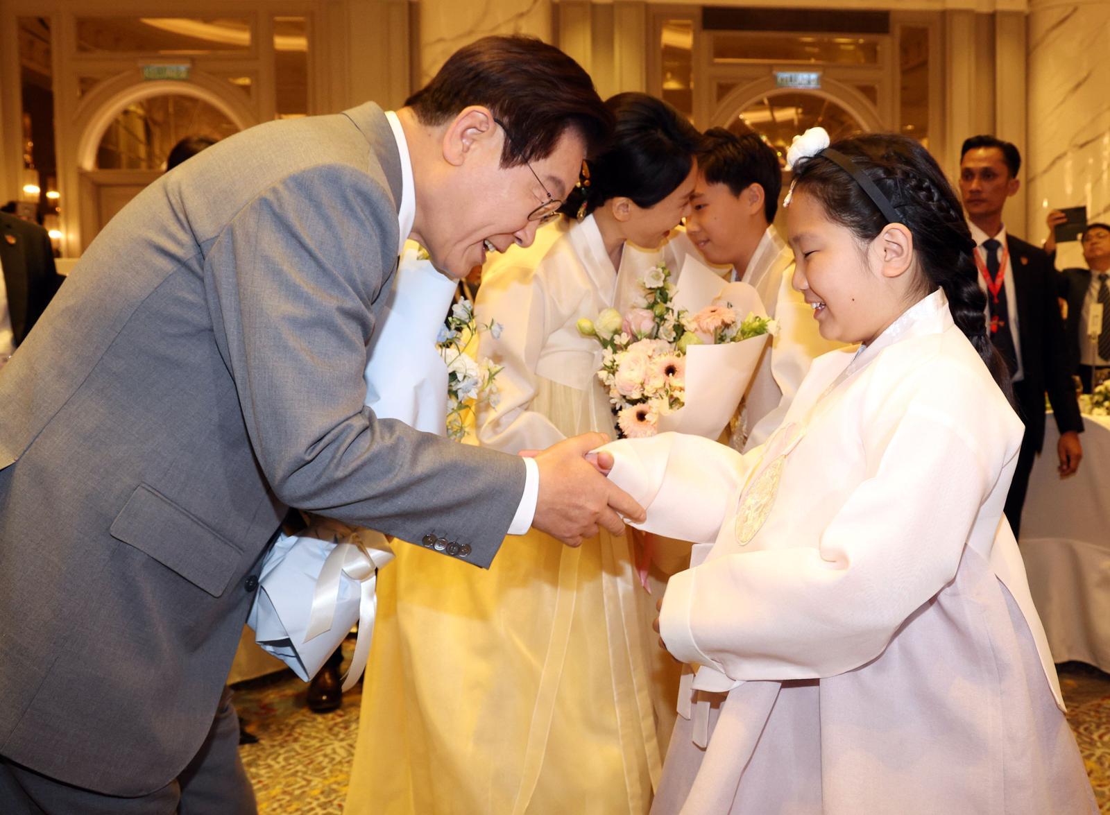 이재명 대통령과 김혜경 여사가 26일(현지 시간) 말레이시아 쿠알라룸푸르 한 호텔에서 열린 동포 간담회에서 화동에게 꽃다발을 받고 있다. 뉴시스