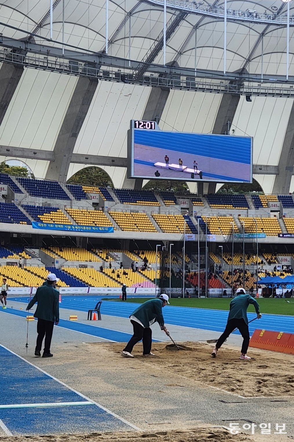 21일 부산 연제구 부산아시아드주경기장 멀리뛰기 경기장에서 육상 심판들이 모래 평탄화 작업을 진행하고 있다. 김화영 기자 run@donga.com