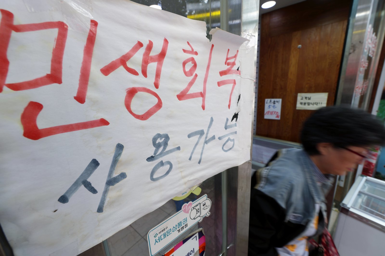 14일 오후 서울시 서대문구 인왕시장의 한 정육점에 ‘민생회복 소비쿠폰’ 사용가능매장을 알리는 안내문이 붙어 있다. 뉴스1