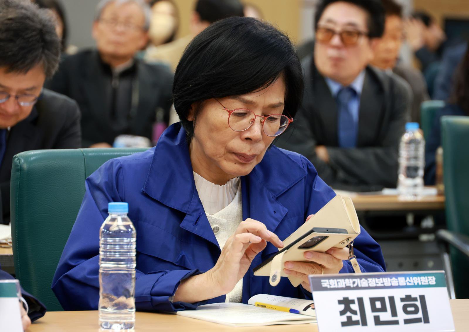 [서울=뉴시스]  최민희 국회 과방위원장이 28일 서울 여의도 국회 의원회관에서 열린 K-바이오 혁신 세미나에서 스마트폰을 보고 있다. 2025.10.28