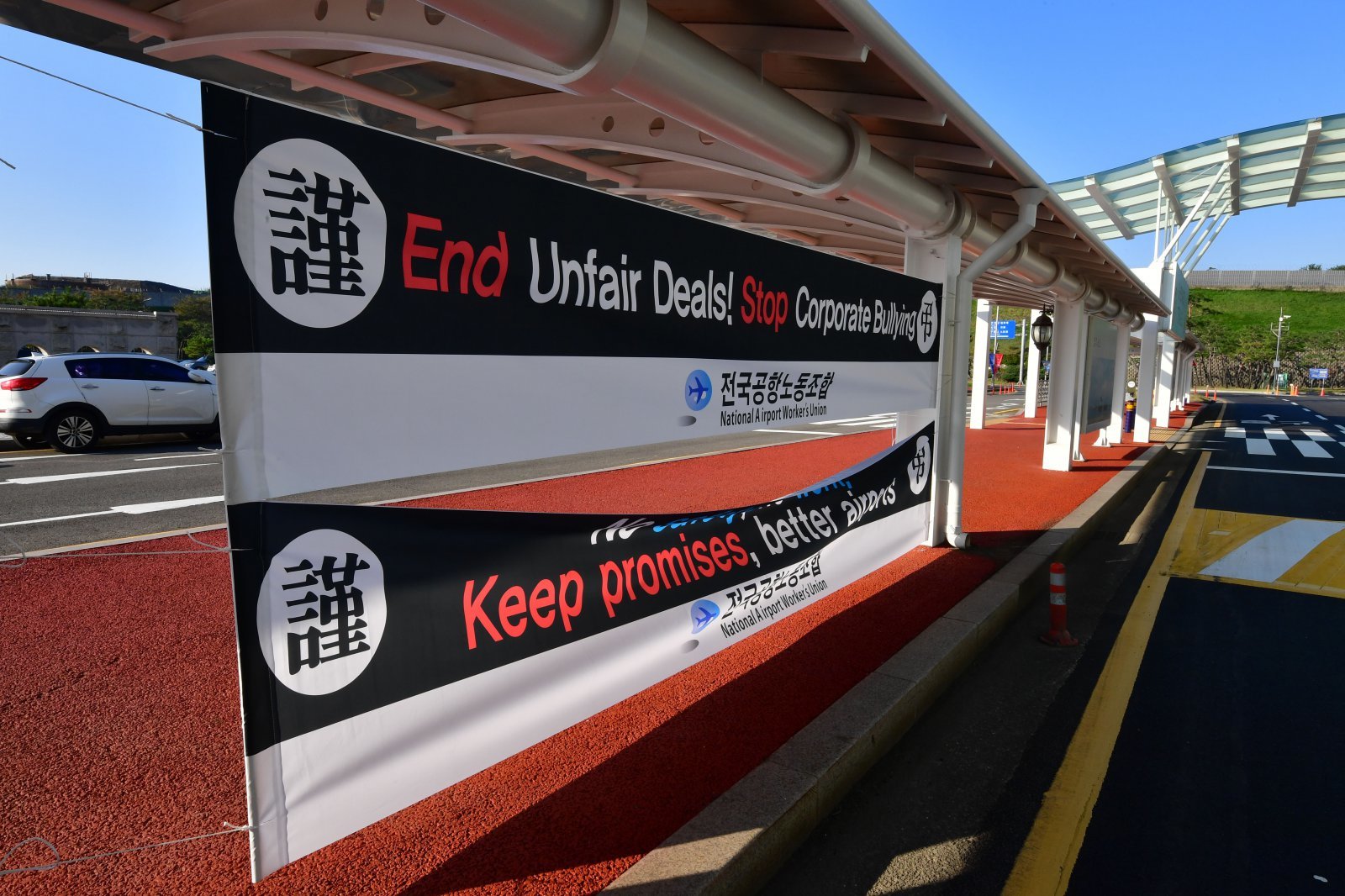 29일 APEC 글로벌 CEO 전용공항인 경북 포항경주공항 입구에 영문으로 된 전국공항 환경미화 주차, 전기 설비 노동자들의 파업, 근조 현수막이 걸려있다. 2025.10.29 뉴스1