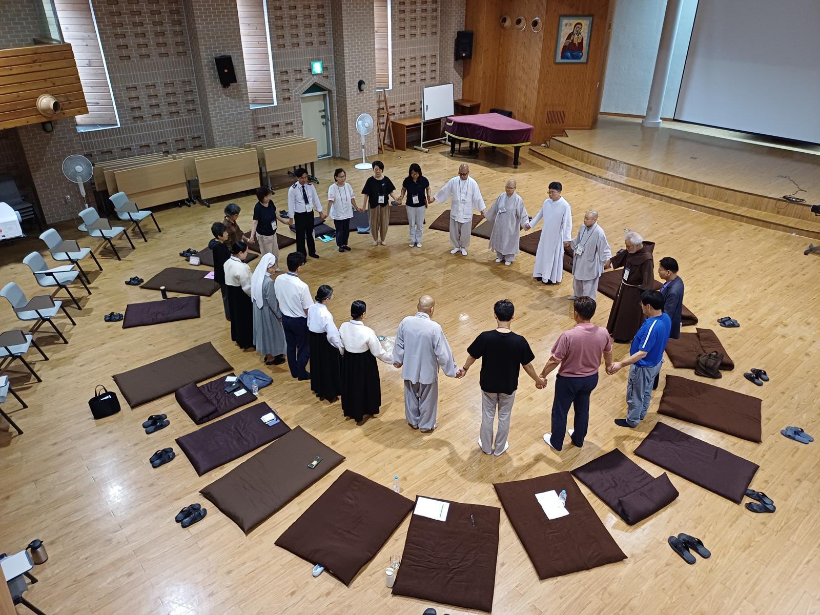 지난달 1, 2일 부산 수영구 올리베따노 성 베네딕도 수녀회에서 열린 ‘한국 수도승 종교 간 대화’ 모임에서 참가자들이 손을 잡고 명상을 하고 있다. 베네딕도회 제공