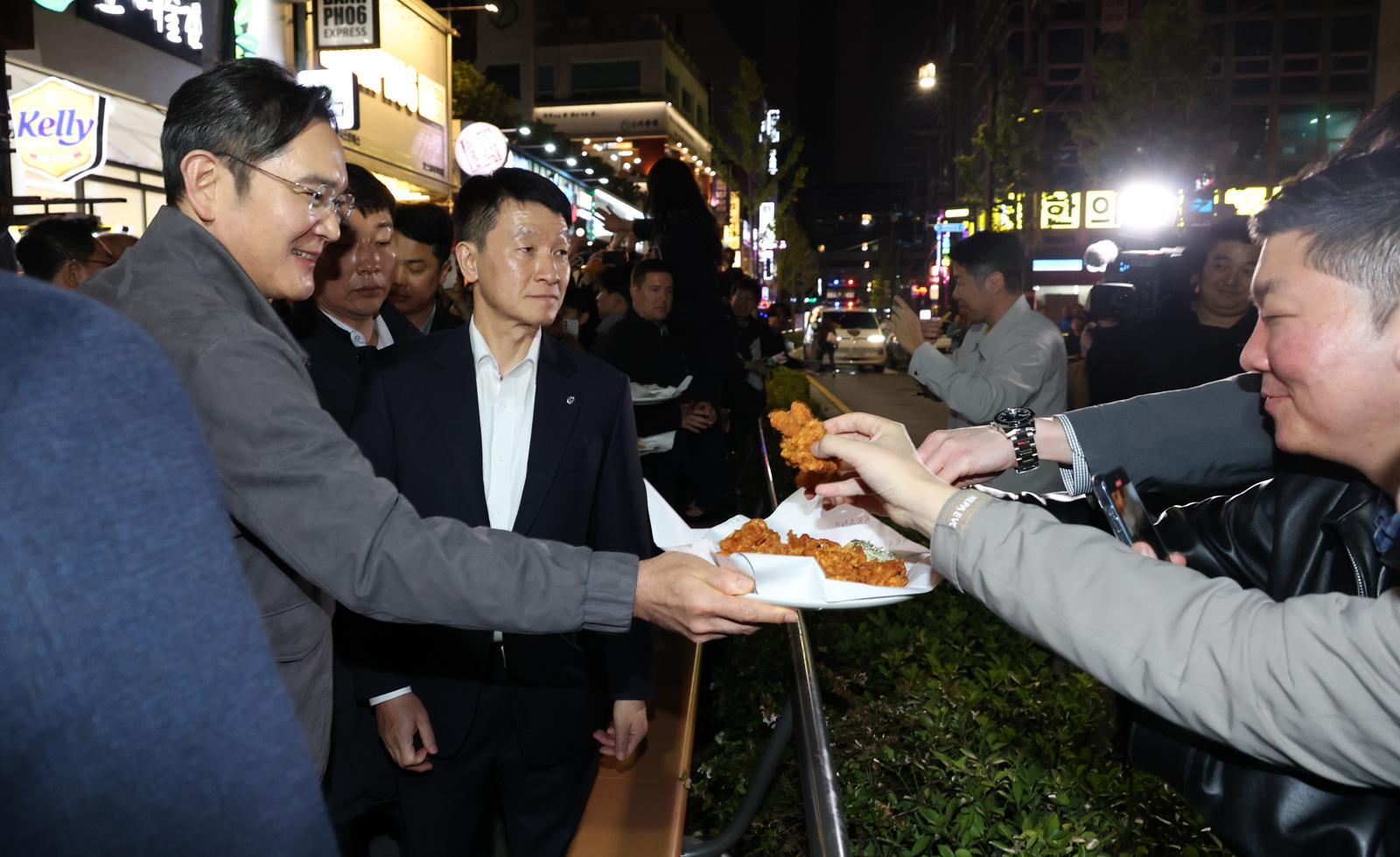 이재용 삼성전자 회장이가 30일 서울 강남구 깐부치킨 삼성점에서 젠슨황 엔비디아 최고경영자와 ‘치맥’ 회동 중 시민들에게 치킨을 나눠주고 있다. 뉴시스