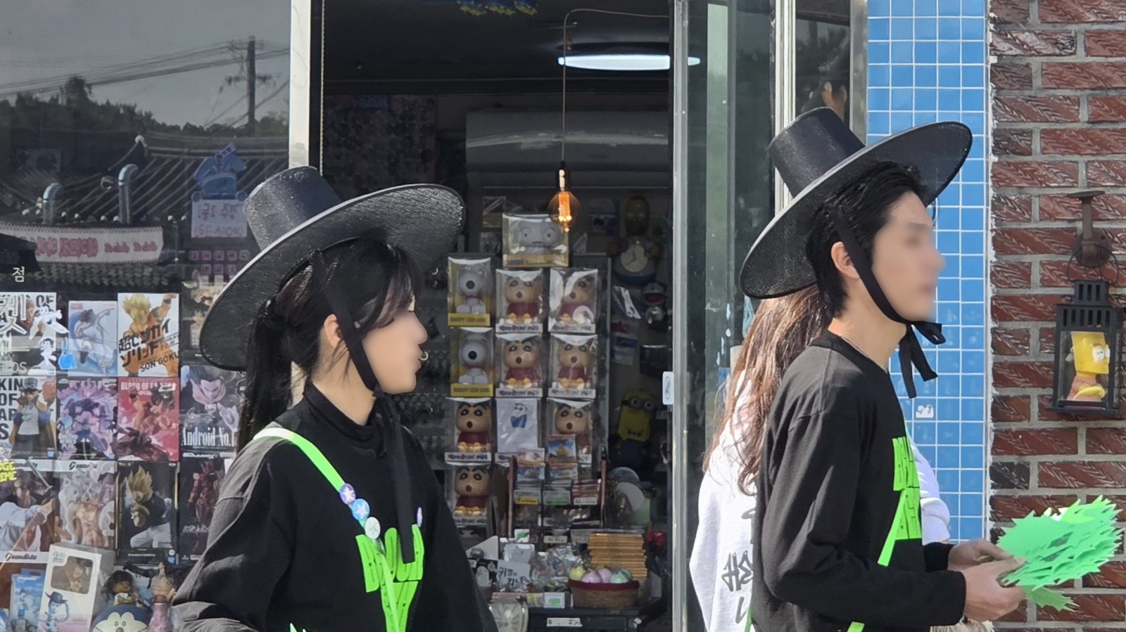 31일 경북 경주 대표 관광지인 황리단길에서 상점 직원이 검은색 갓을 착용한 채 홍보 전단지를 돌리고 있다. 2025.10.31 뉴스1