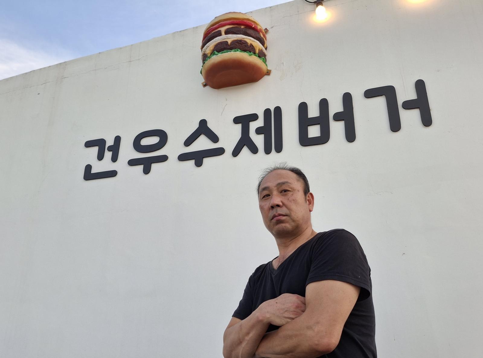 자신의 이름을 딴 수제버거 집 앞에서 포즈를 취한 김건우.   김건우 제공