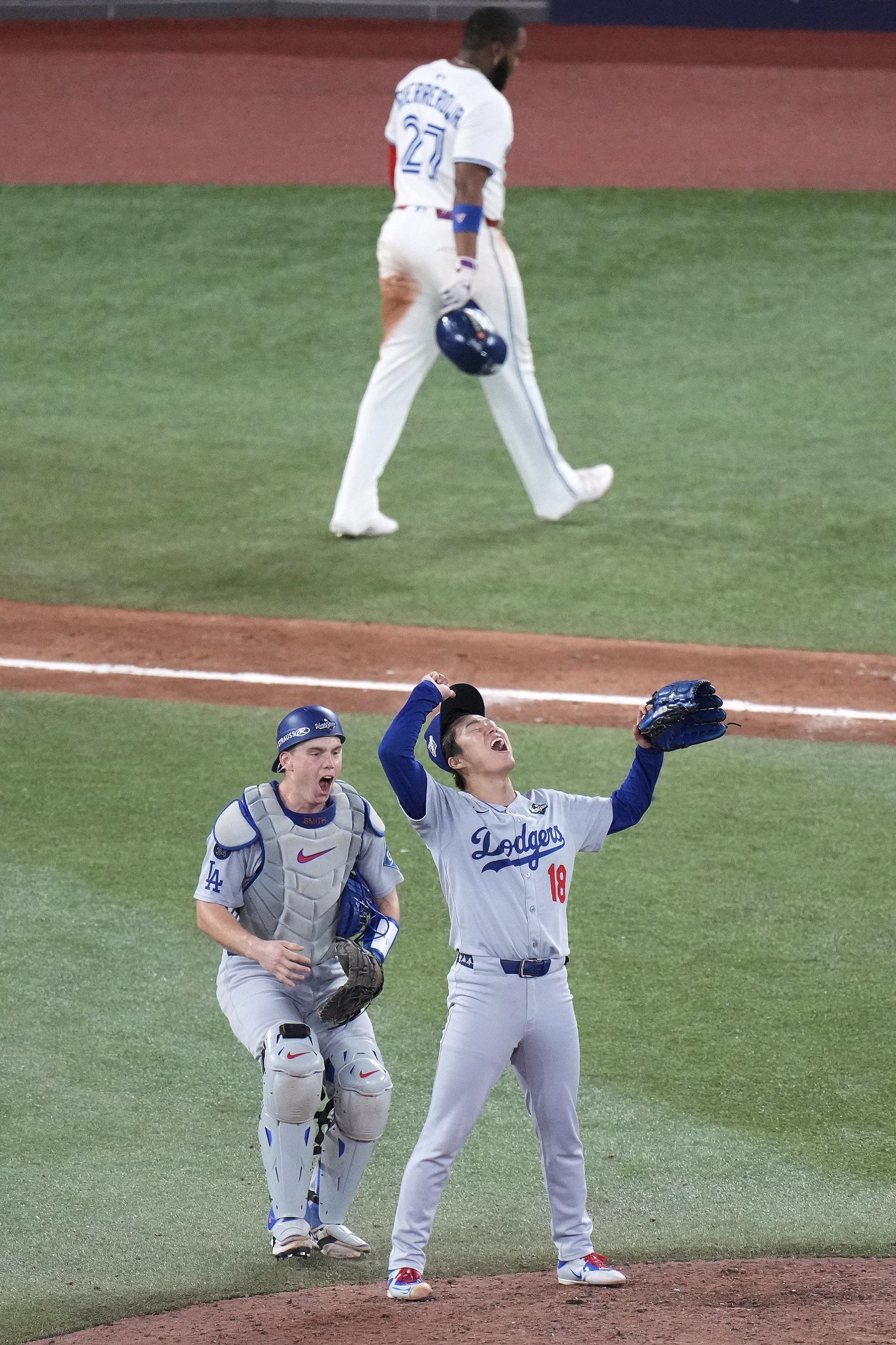 2025 월드시리즈 우승을 확정한 뒤  포효하는 야마모토 요시노부(앞줄 오른쪽)와 윌 스미스(앞줄 왼쪽). 뒤쪽으로 연장 11회말 토론토 선두타자로 나와 2루타를 치고 나갔지만 홈으로 돌아오지 못한 블라디미르 게레로 주니어가 더그아웃을 향해 걸어가고 있다. 토론토=AP 뉴시스