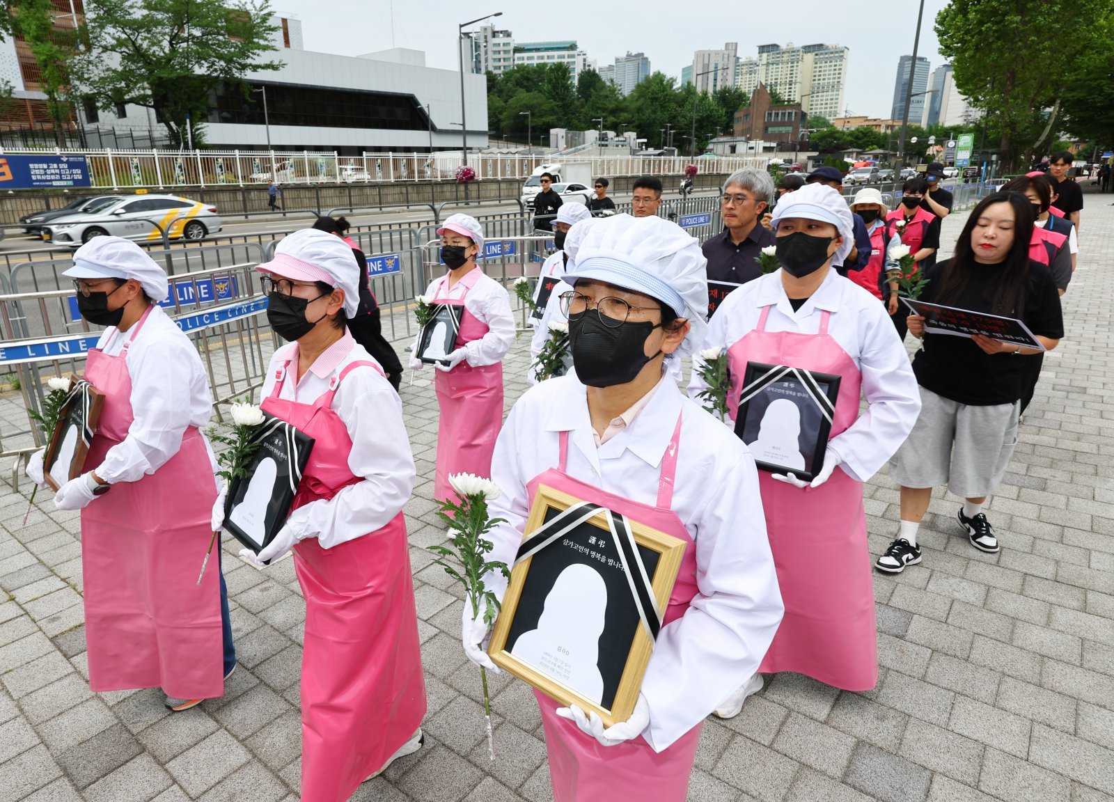 서울 용산구 대통령실 앞에서 열린  죽음의 학교 급식실 폐암 산재 문제 해결을 위한 학교급식법 개정 촉구 기자회견에서 참석자들이 대통령실에 요구안을 전달하기 위해 행진하고 있다. (출처=뉴시스)