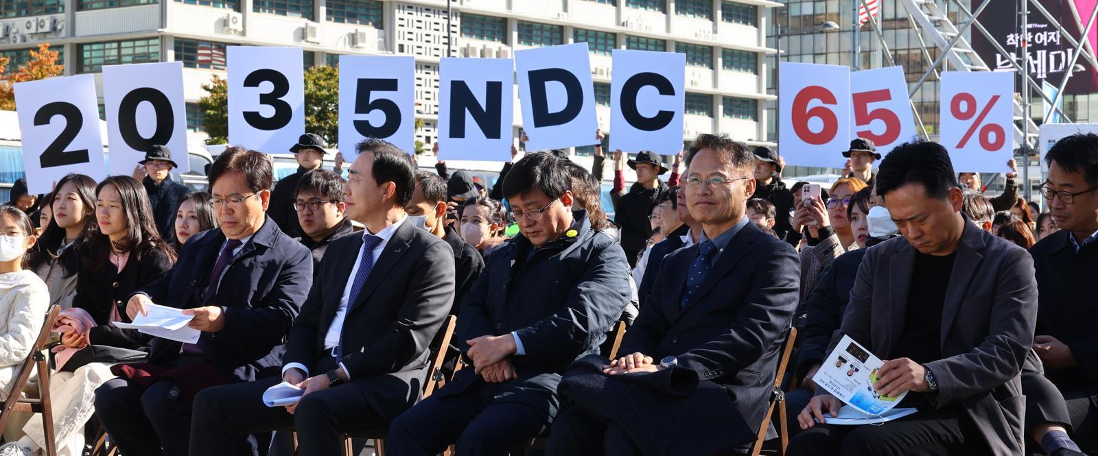 27일 서울 광화문광장에서 김성환 기후에너지환경부 장관(앞줄 오른쪽에서 세번째)이 참석한 제3회 지구하다 페스티벌 개막식에서 기후위기비상행동 회원들이 2035년 국가 온실가스 감축목표(NDC) 65% 수립을 촉구하는 피켓을 들어보이고 있다. 2025.10.27 뉴시스