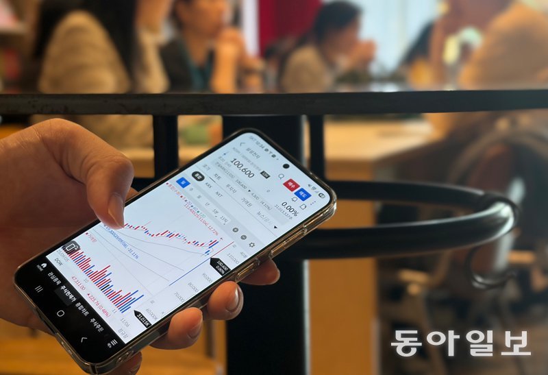 코스피가 4000을 돌파하는 등 시장이 좋아지면서 시도 때도 없이 주식을 하는 이들이 늘고 있다. 테이블 아래서 주식을 하는 모습. 송은석 기자 silverstone@donga.com